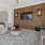 a living room with a large tv and a large stone wall